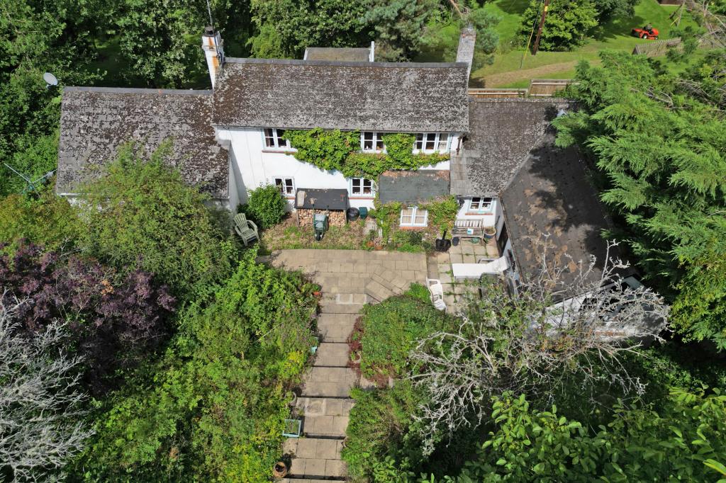 Lot: 113 - DETACHED COTTAGE FOR IMPROVEMENT ON 0.3 ACRE PLOT - Aerial shot showing cottage and grounds